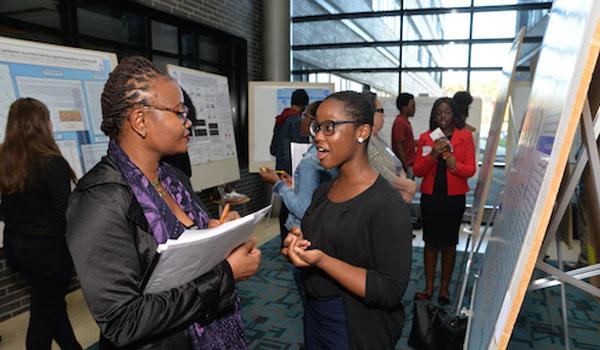 Two ladies standing at a poster presentation